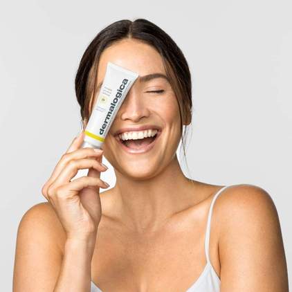 DERMALOGICA Invisible Physical Defense SPF30 – Ein physikalischer Lichtschutz mit leichter Textur, der schnell einzieht und keine weißlichen Rückstände hinterlässt, die normalerweise typisch für viele physikalische Lichtschutzmittel sind., 50ml, Frau mit Produkt