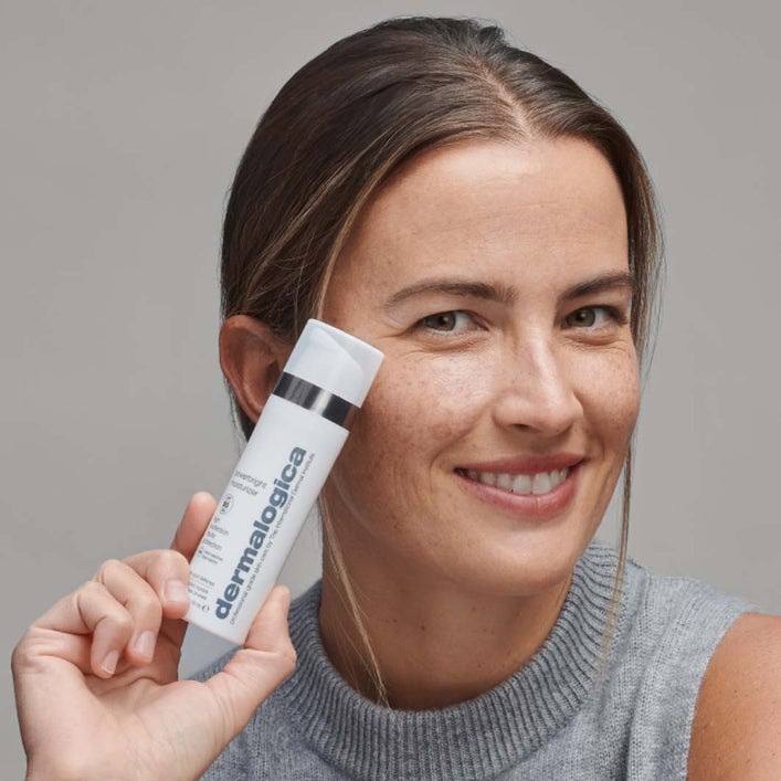 DERMALOGICA Powerbright Dark Spot Moisturizer SPF50 – hilft, dunkle Flecken zu bekämpfen und die Haut vor der Sonne zu schützen, um weiteren Pigmentflecken vorzubeugen., 50ml, Frau zeigt Produkt
