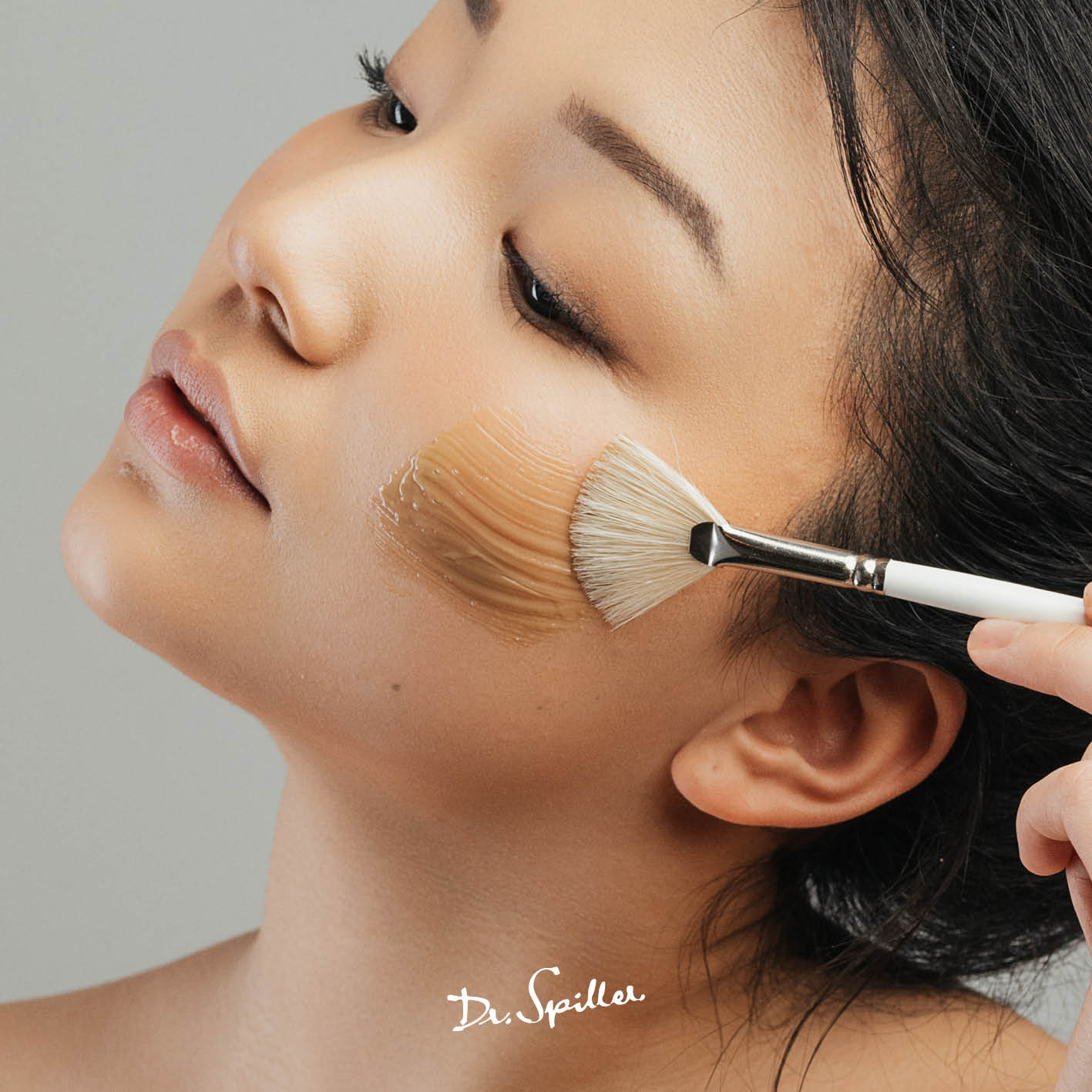 Frau trägt Dr. Spiller Kräuter Maske mit Pinsel auf