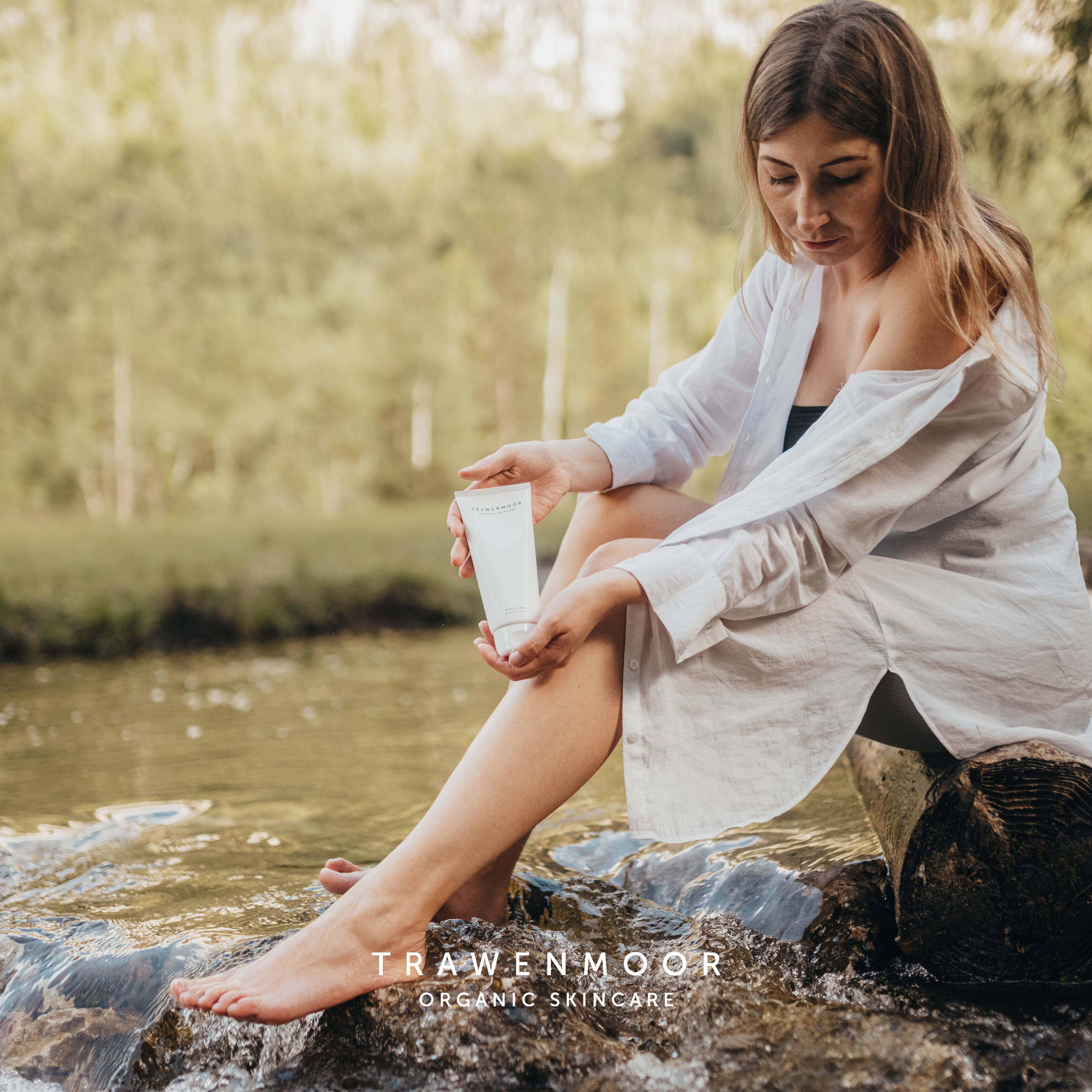 DR SPILLER TRAWENMOOR Body Care – 200ml, Frau hält Tube an Flußufer sitzend