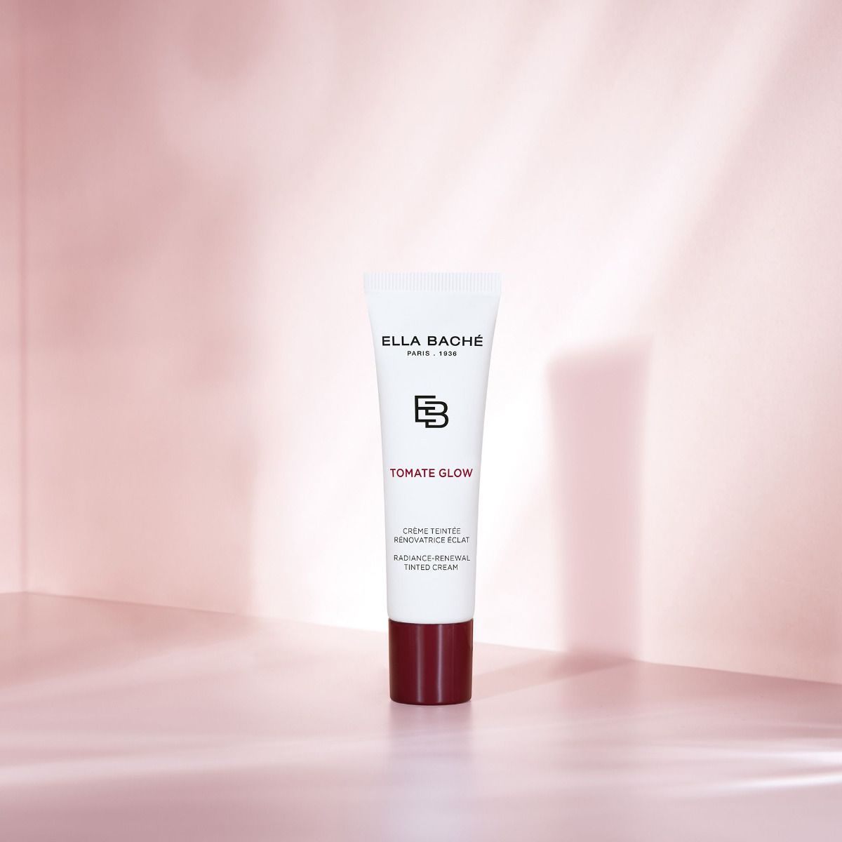 ELLA BACHE Tomate Glow - Radiance-Renewal Tinted Cream – getönte Tagescreme, 30ml, Tube vor rosa Hintergrund