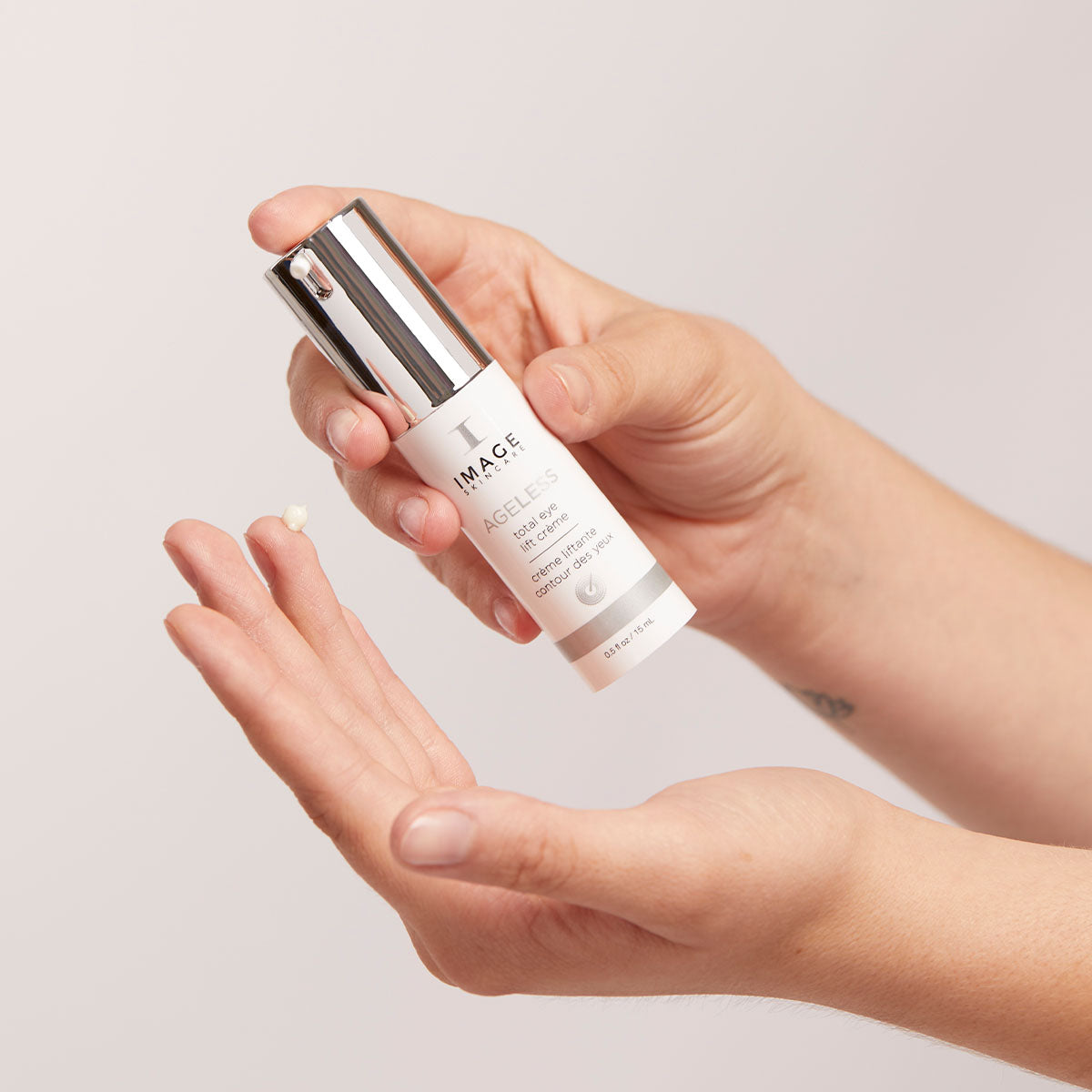IMAGE SKINCARE Ageless Total Eye Lift Crème – 15ml, Hände geben Augencreme auf Fingerspitze