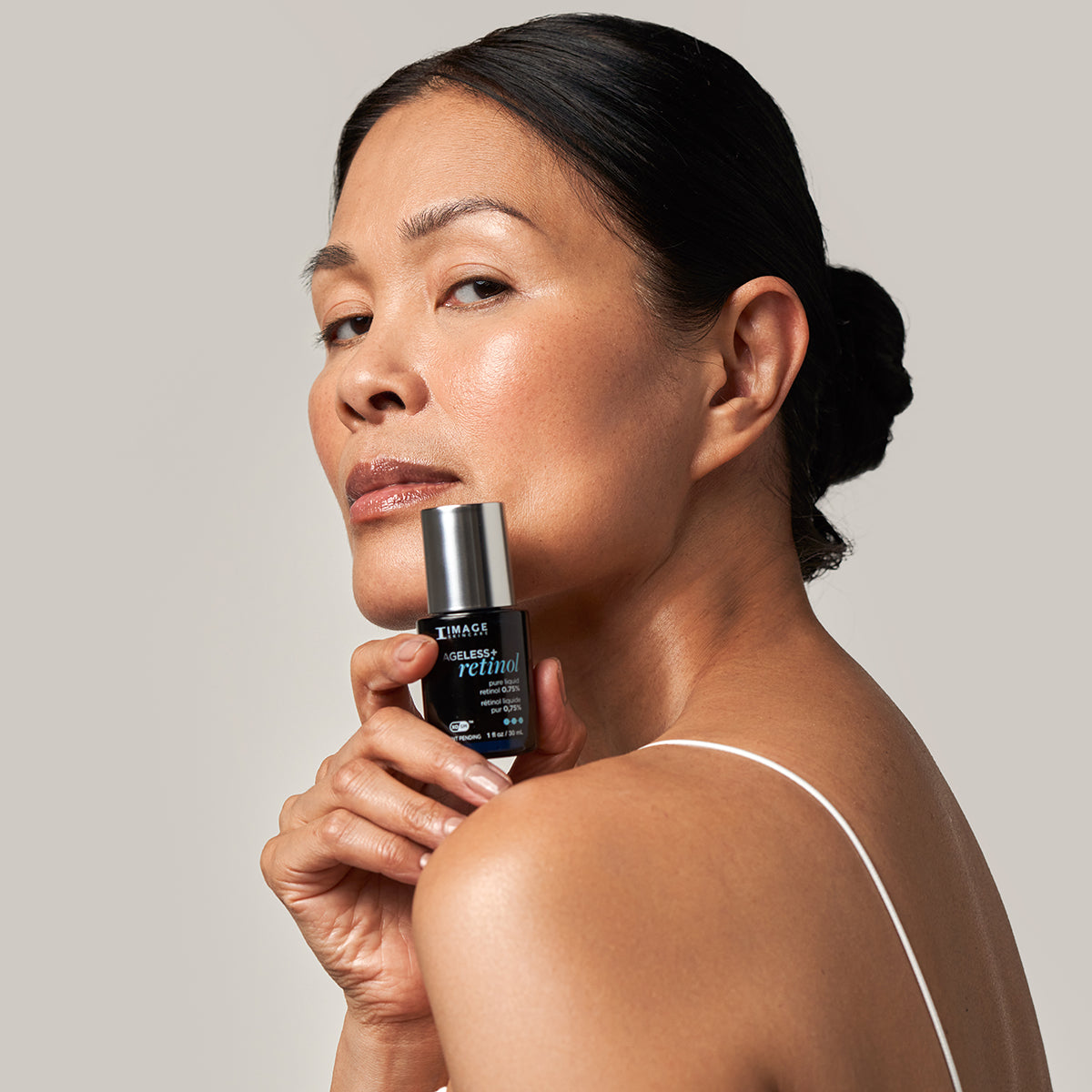 IMAGE SKINCARE Ageless+ Retinol pure liquid retinol 0.75% – Retinol-Serum, 30ml, Frau hält Serum