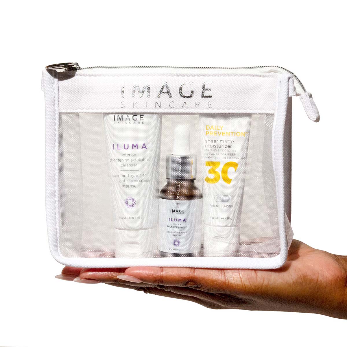 IMAGE SKINCARE Brighten & Protect Kit – Reisegrößen-Set, 1stk, Hand hält Kosmetiktasche mit Produkten
