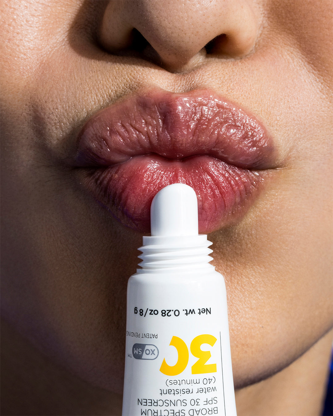 IMAGE SKINCARE DAILY PREVENTION nourishing lip balm SPF 30 – 8g, Frau hält Tube vor Lippen