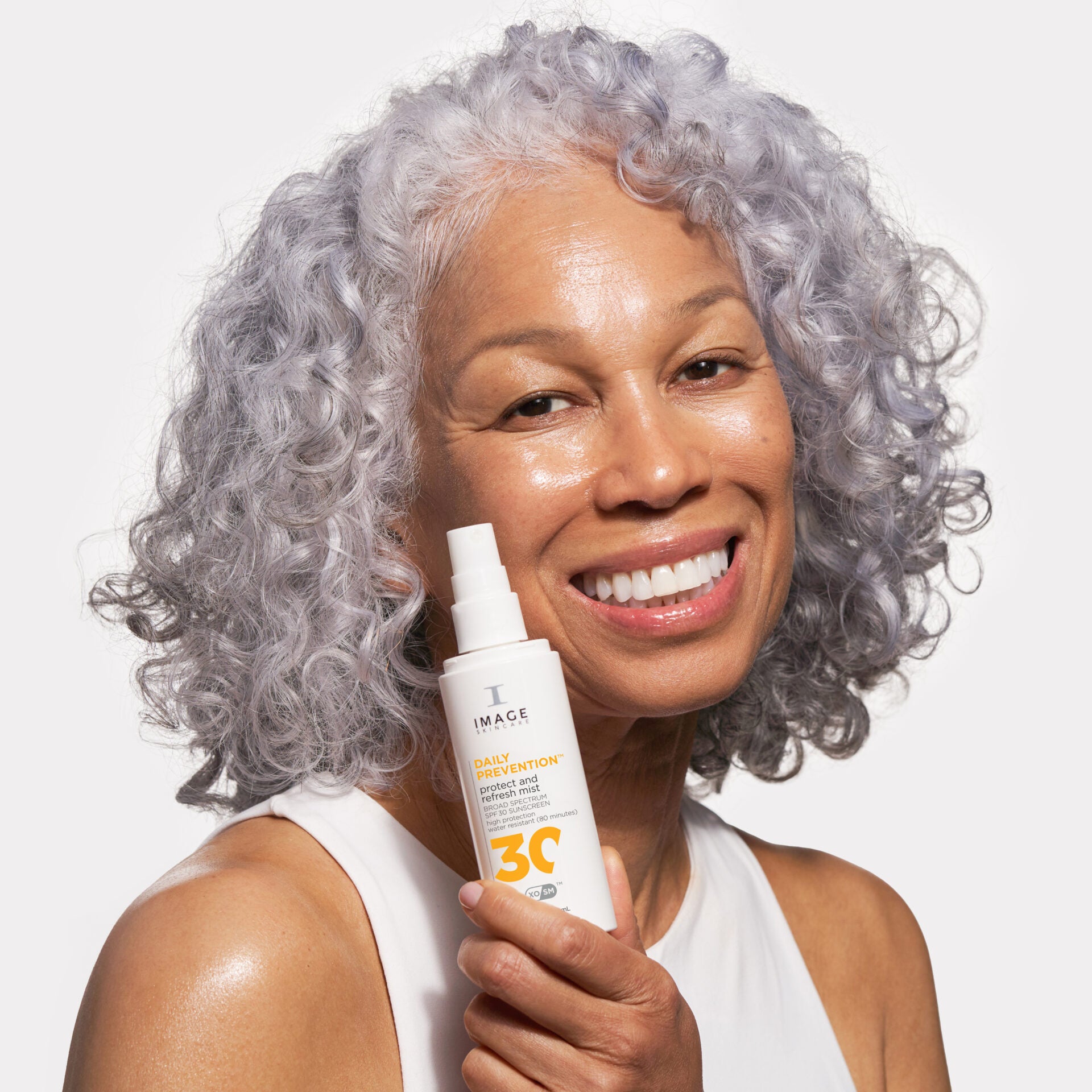 IMAGE SKINCARE DAILY PREVENTION protect and refresh mist SPF 30 – Sonnenschutzspray, 100ml, Frau hält Sprühflasche