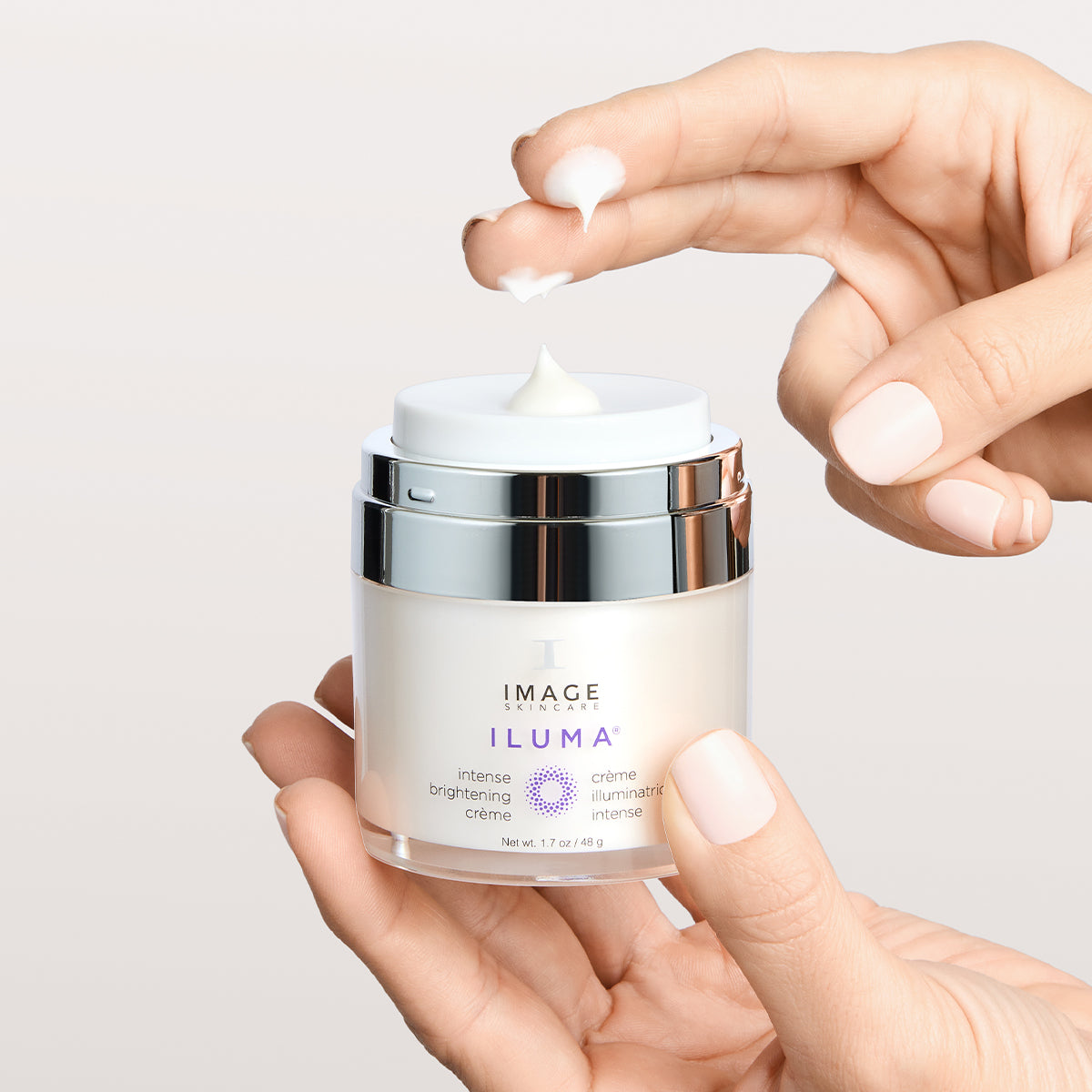IMAGE SKINCARE ILUMA™ Intense Brightening Crème – Aufhellende Pflege gegen Pigmentflecken, 48g, Hände entnehme Creme aus Tiegel