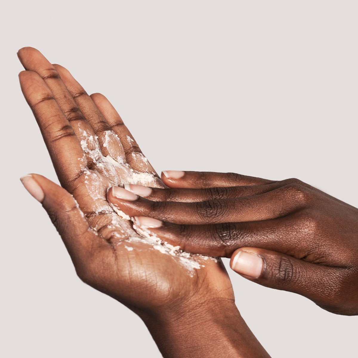 IMAGE SKINCARE ILUMA™ Intense Brightening Exfoliating Powder – Peeling-Puder mit Aufhellungseffekt, 43g, Hände schäumen Peelingpuder in Handfläche auf