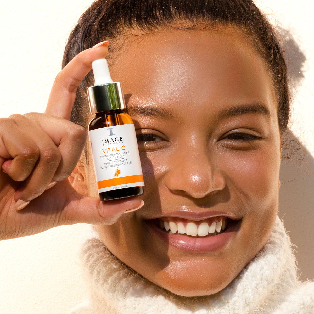 IMAGE SKINCARE Vital C Hydrating Antioxidant ACE Serum – 30ml, Frau hält Serum vor Gesicht