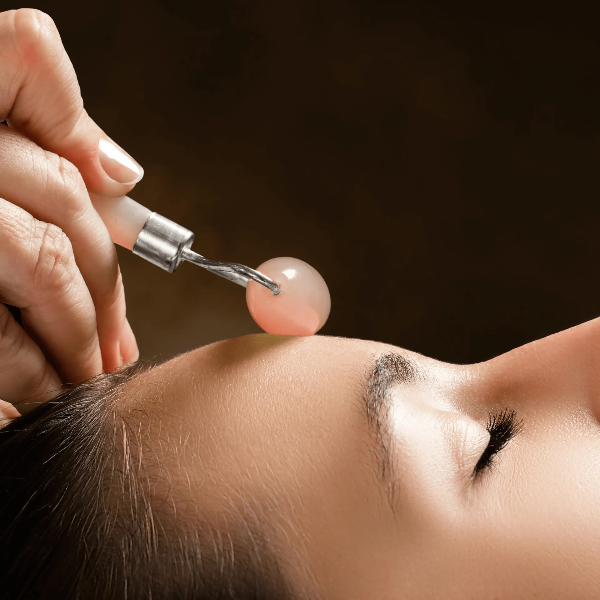 LAPIS VITALIS Chi Massageroller Rosenquarz, 1stk, Hand wendet Roller auf Stirn an