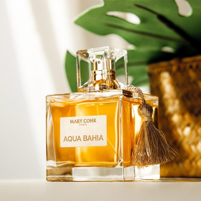 MARY COHR Aqua Bahia – Eau de Parfum, 100ml, Flacon stehend vor Topfpflanze