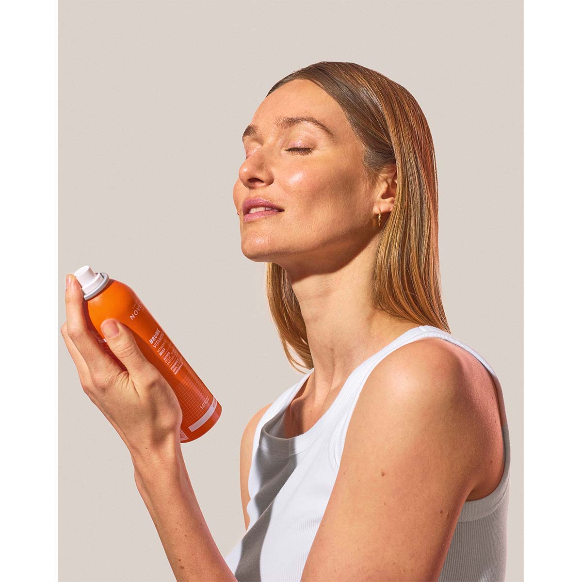 NOVEXPERT Vitamin C Mist – 150ml, Frau sprüht Gesicht ein