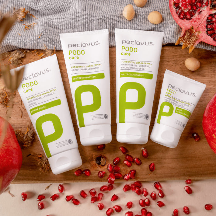 PECLAVUS Geschenk-Set Granatapfel – 3x100ml+30ml, Einzelprodukte auf Holz liegend mit Granatapfelkernen