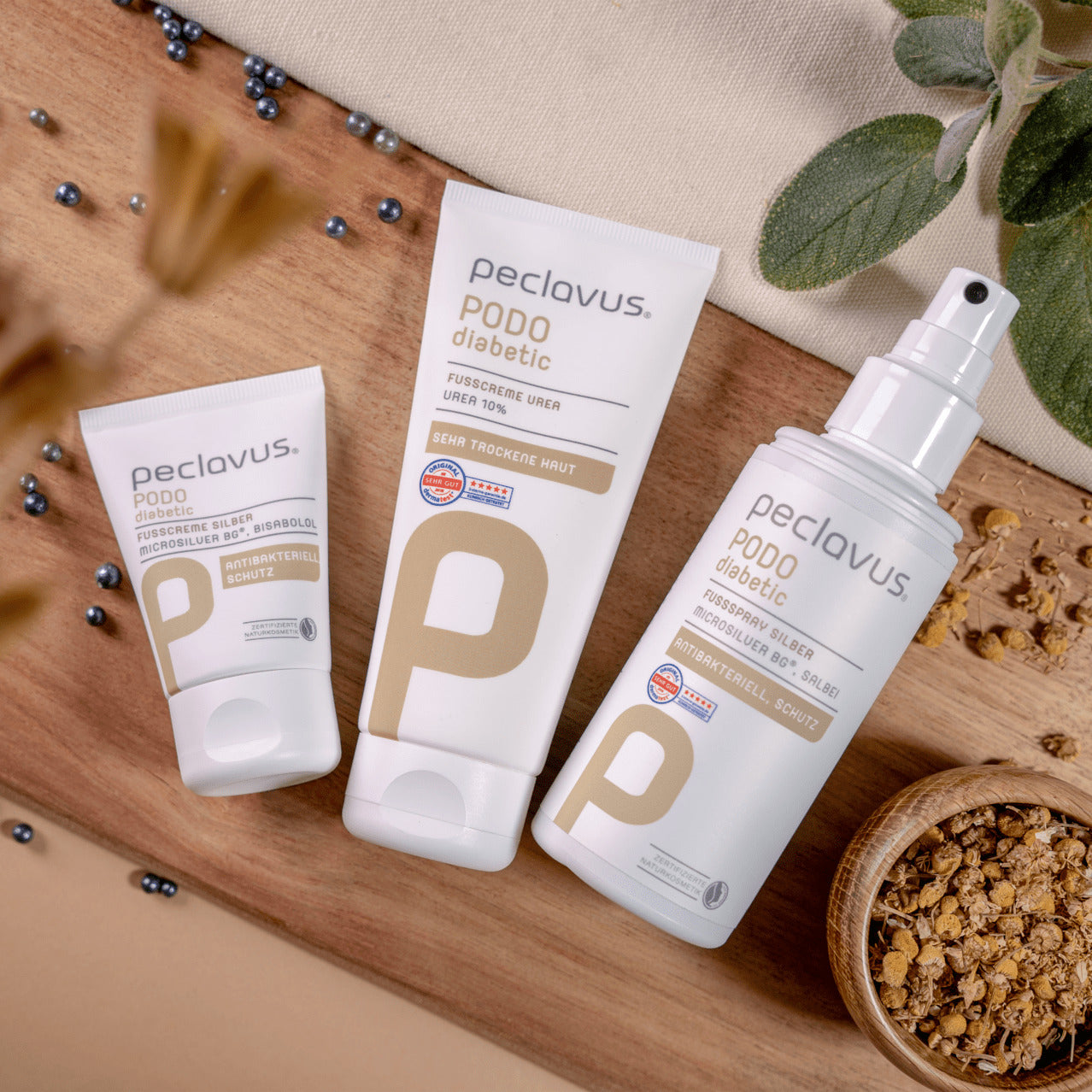 PECLAVUS Geschenk-Set Sensible Füße, ., Einzelprodukte auf Holz liegend mit Silberkugeln und Kamillenblüten