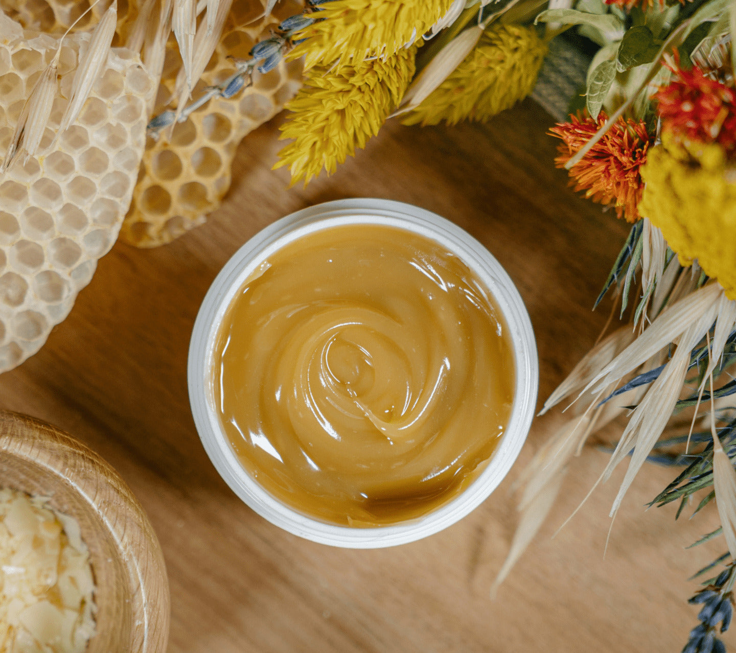 PECLAVUS Schrundensalbe – 50ml, Tiegel offen auf Holzplatte mit Bienenwaben und Trockenblumen