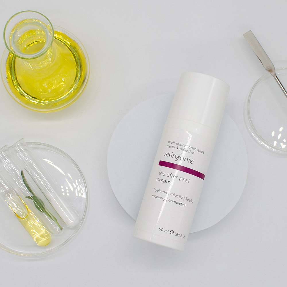 SKINFONIE the after peel cream – reichhaltige Feuchtigkeitscreme, 50ml, Spender liegend mit Laborutensilien