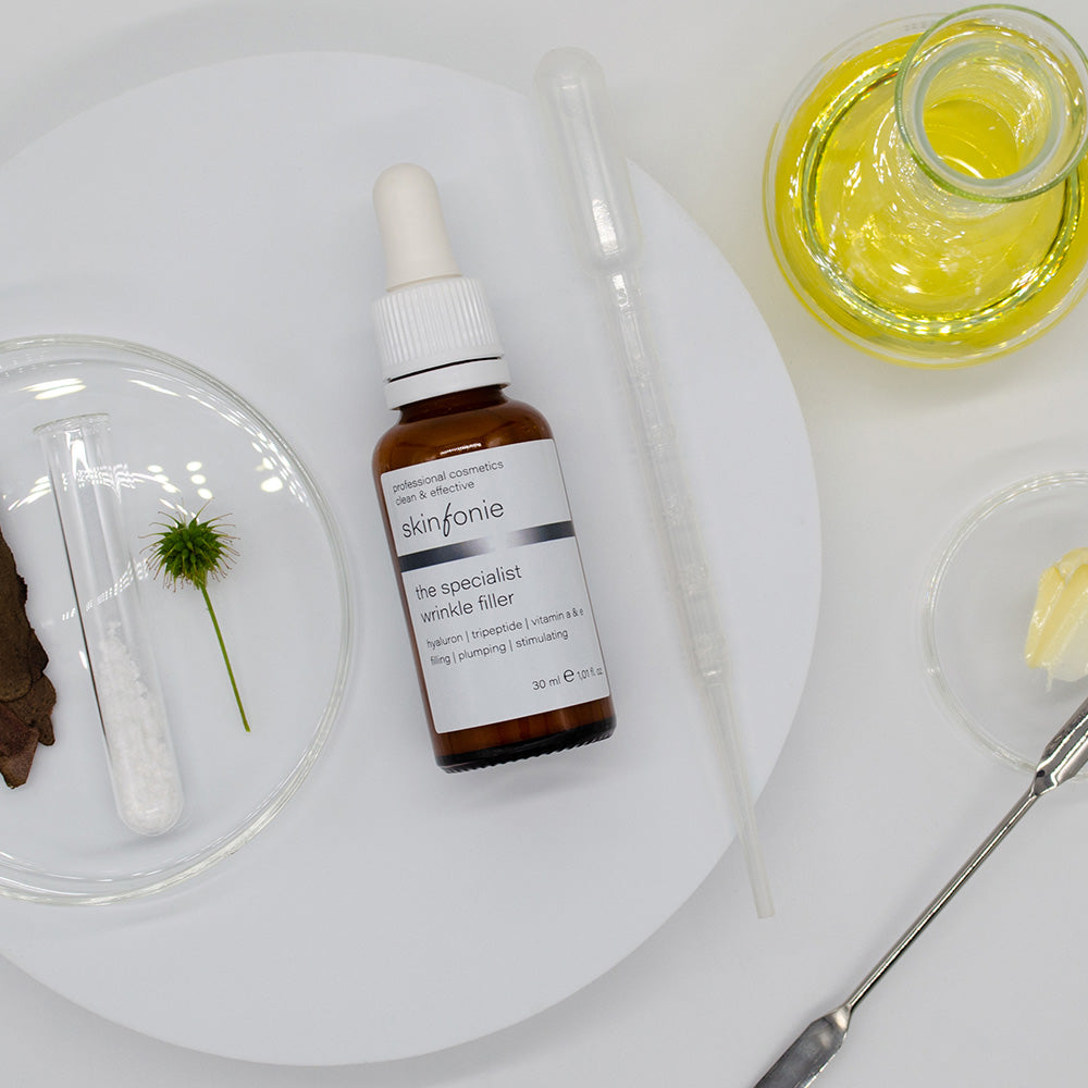 SKINFONIE the specialist wrinkle filler – Serum, 30ml, Pippetenflasche liegend mit Laborutensilien