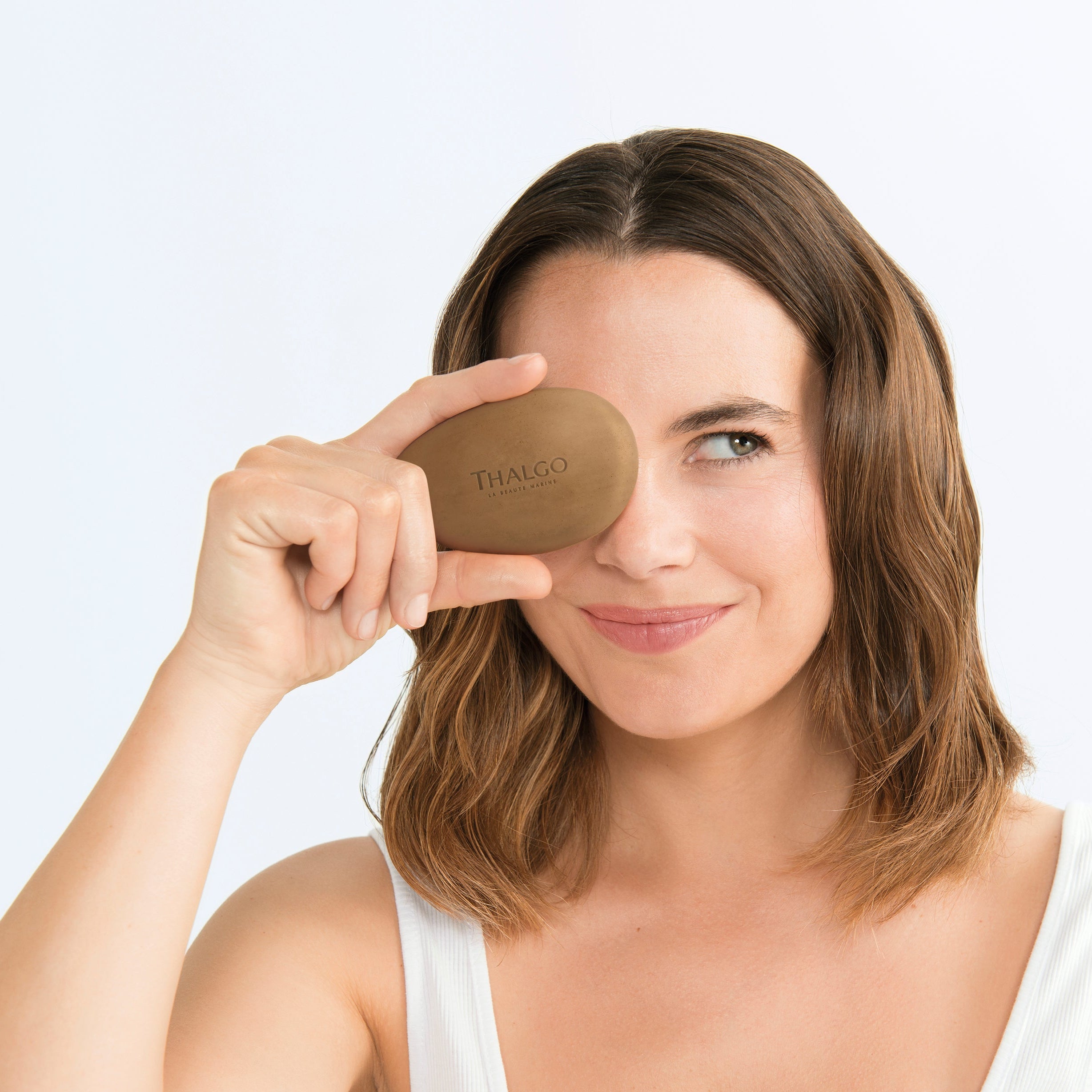 THALGO Éveil à la Mer - Algenseife Gesicht – 100g, Frau hält Seife vor Gesicht