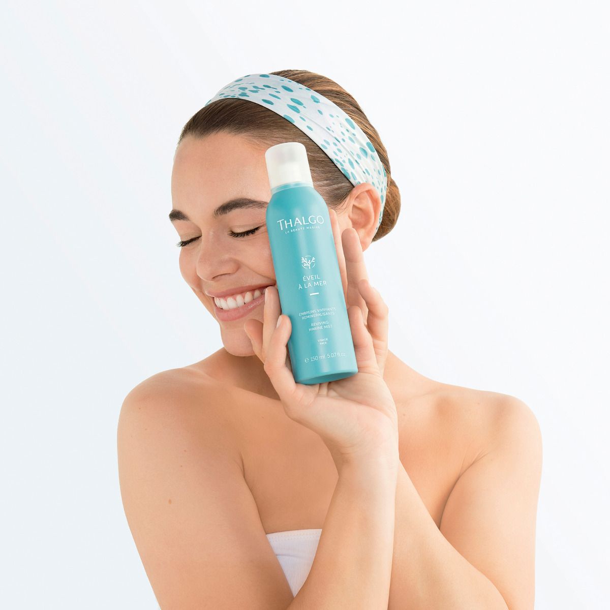 THALGO Éveil à la Mer - Remineralisierendes Meerwasser-Spray – 150ml, Frau hält Sprühflasche