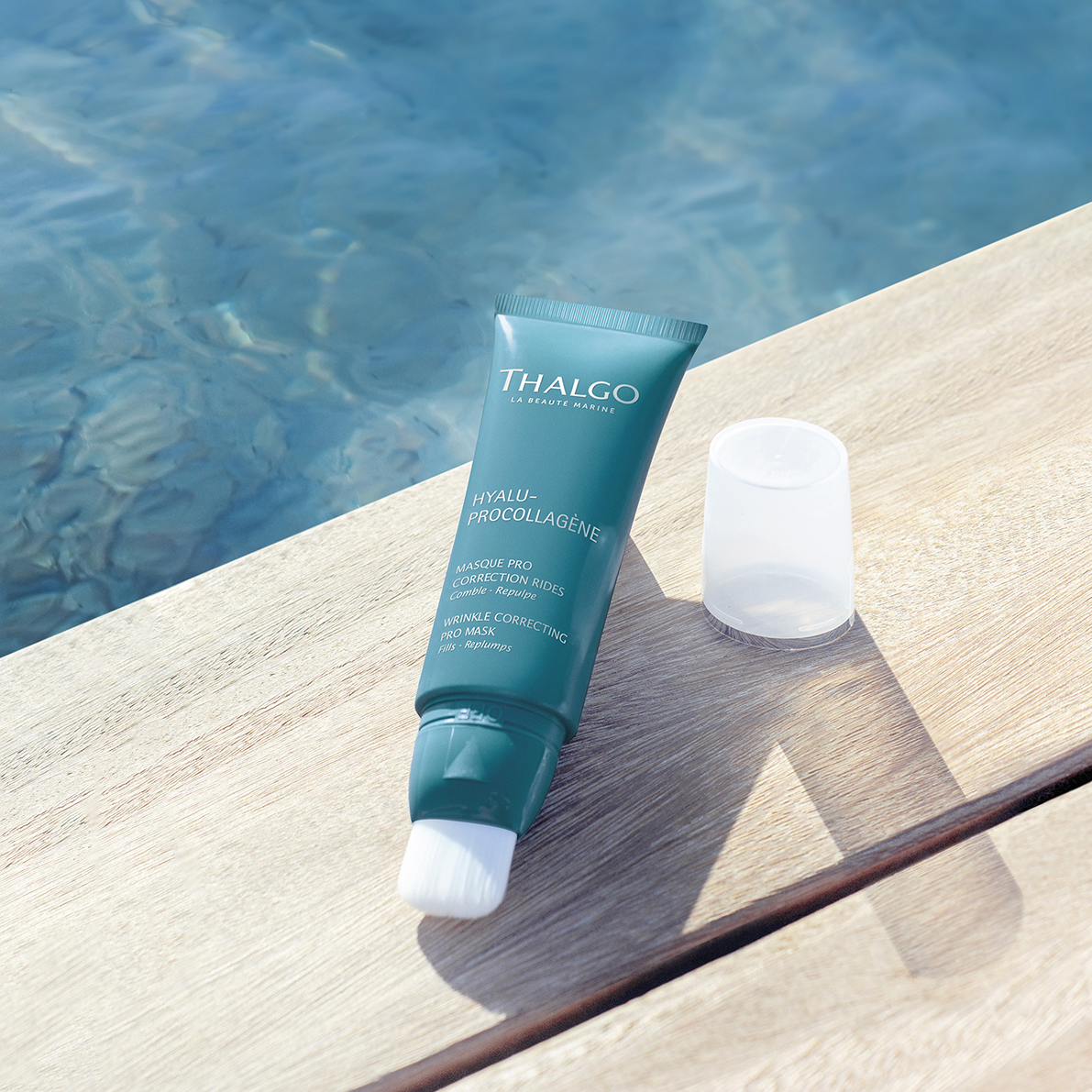 THALGO HYALU-PROCOLLAGÈNE - Faltenkorrigierende Maske – 50ml, offene Tube auf Holzsteg an Wasser
