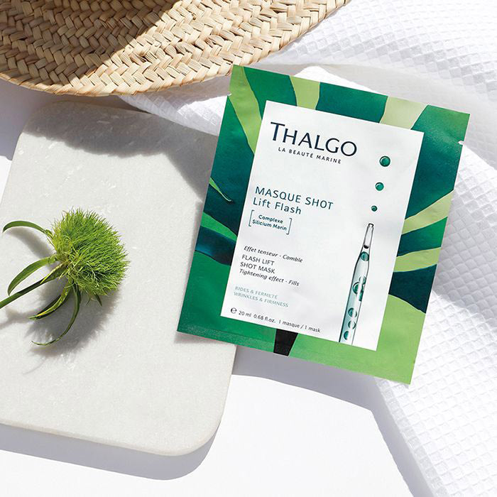 THALGO Masque Shot - Lifting-Maske mit Sofort Effekt – 20ml, Sachet auf weißem Stoff mit Distel auf Steinplatte