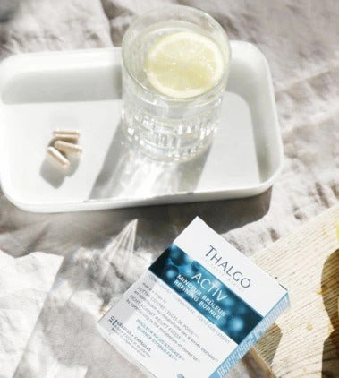 THALGO Minceur Bruleur Kapseln – Nahrungsergänzung, 16,5g, Kapseln auf Tablett mit Glas Zitronenwasser und Umkarton liegend