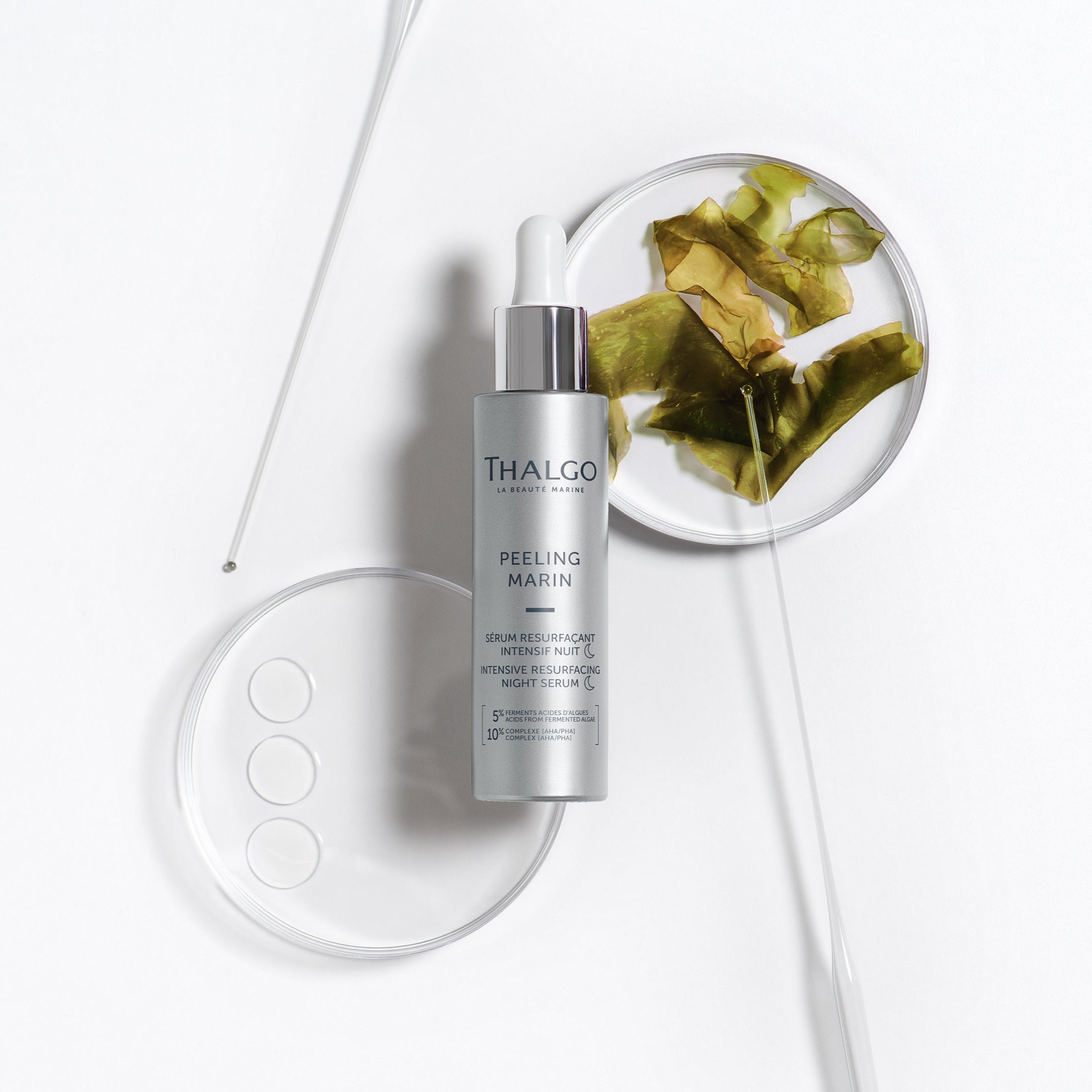 THALGO Peeling Marin - Erneuerndes Intensiv-Serum für die Nacht , 30ml, Spenderflasche liegend mit Algen in Petrischalen und Glaspipetten
