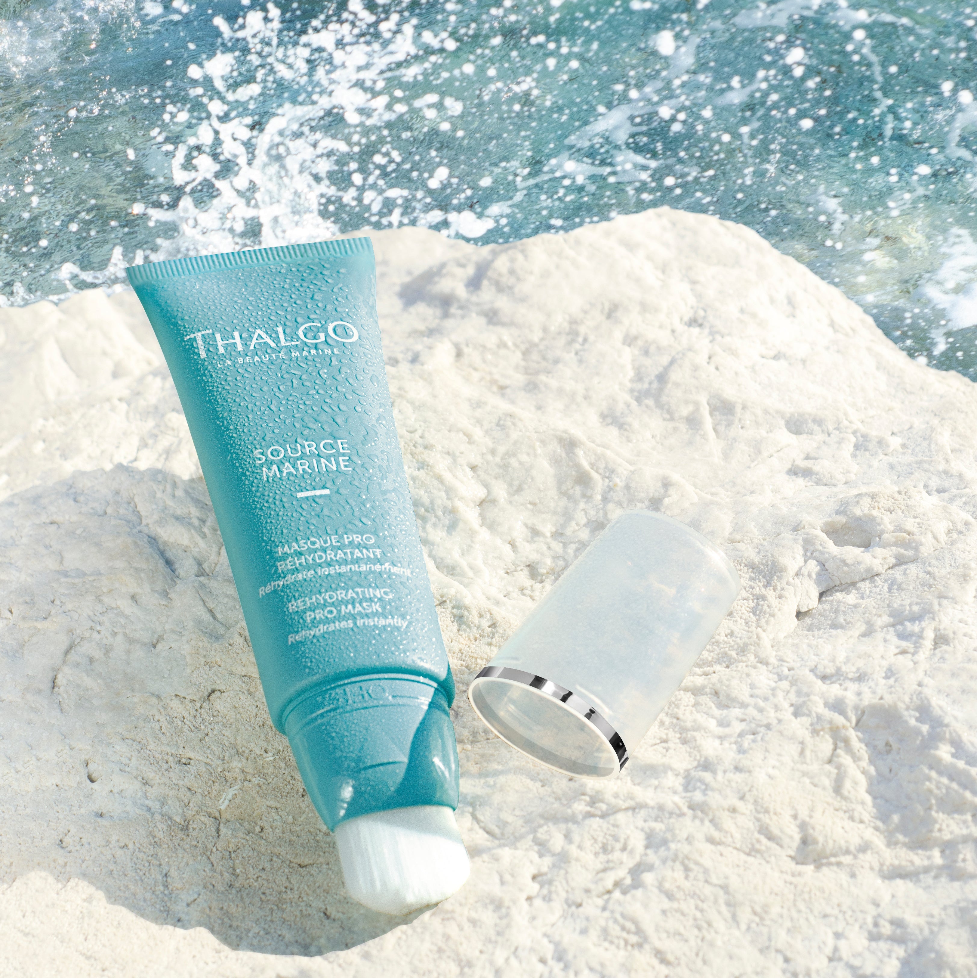 THALGO Source Marine - Feuchtigkeitsspendende Maske – 50ml, Tube offen auf Steinufer liegend