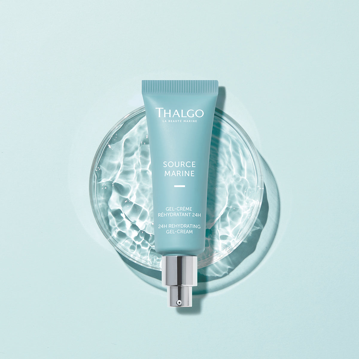 THALGO Source Marine - Gel-Créme Réhydratant 24h - Kühlendes Feuchtigkeitsfluid – Feuchtigkeitsfluid mit Hyaluronsäure, 40ml, Tube auf Wasserschale vor blauem Hintergrund