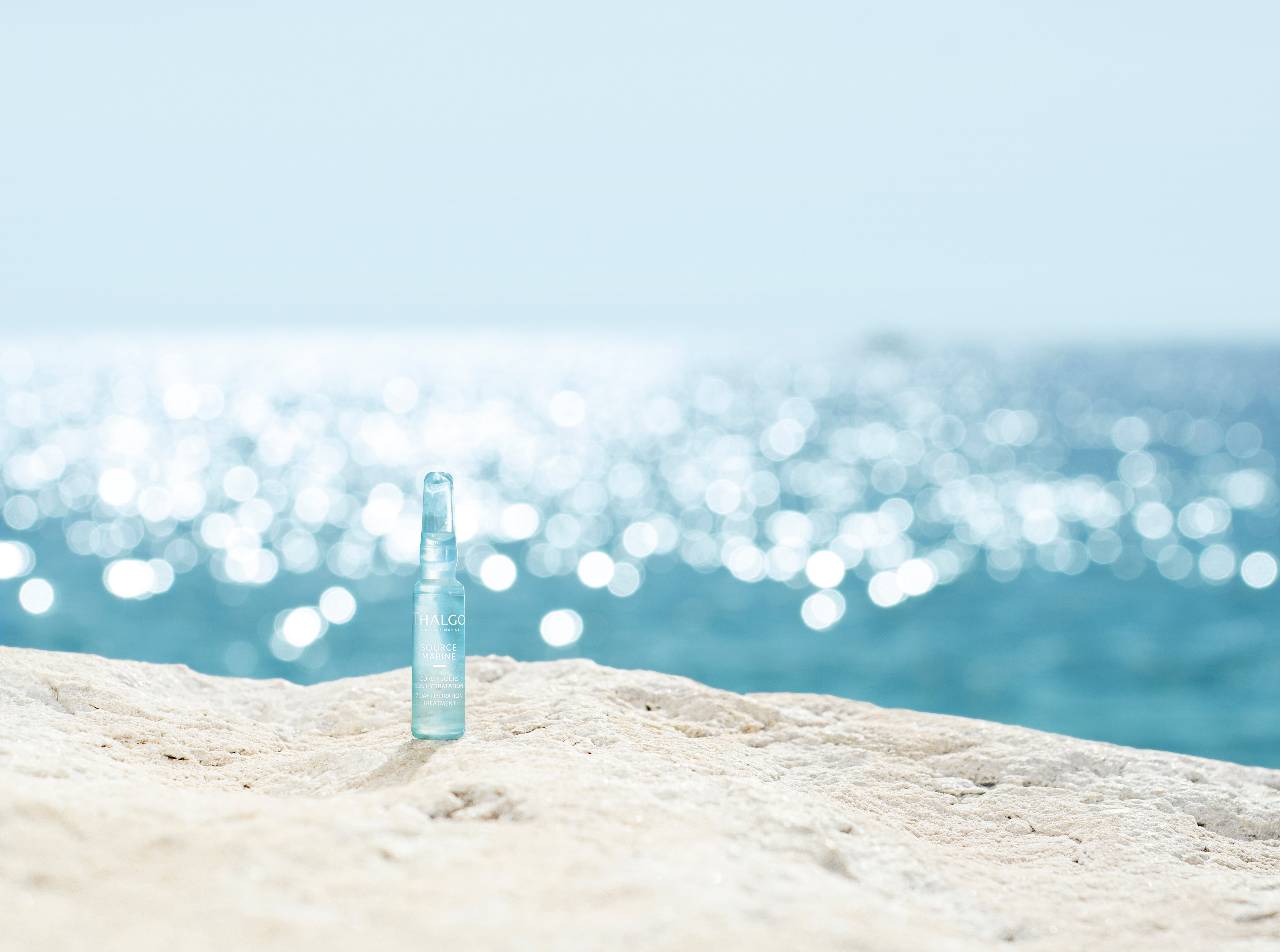 THALGO Source Marine - Hydra-Boost Ampullen – 1,2ml, Einzelampulle auf Steinufer am Meer
