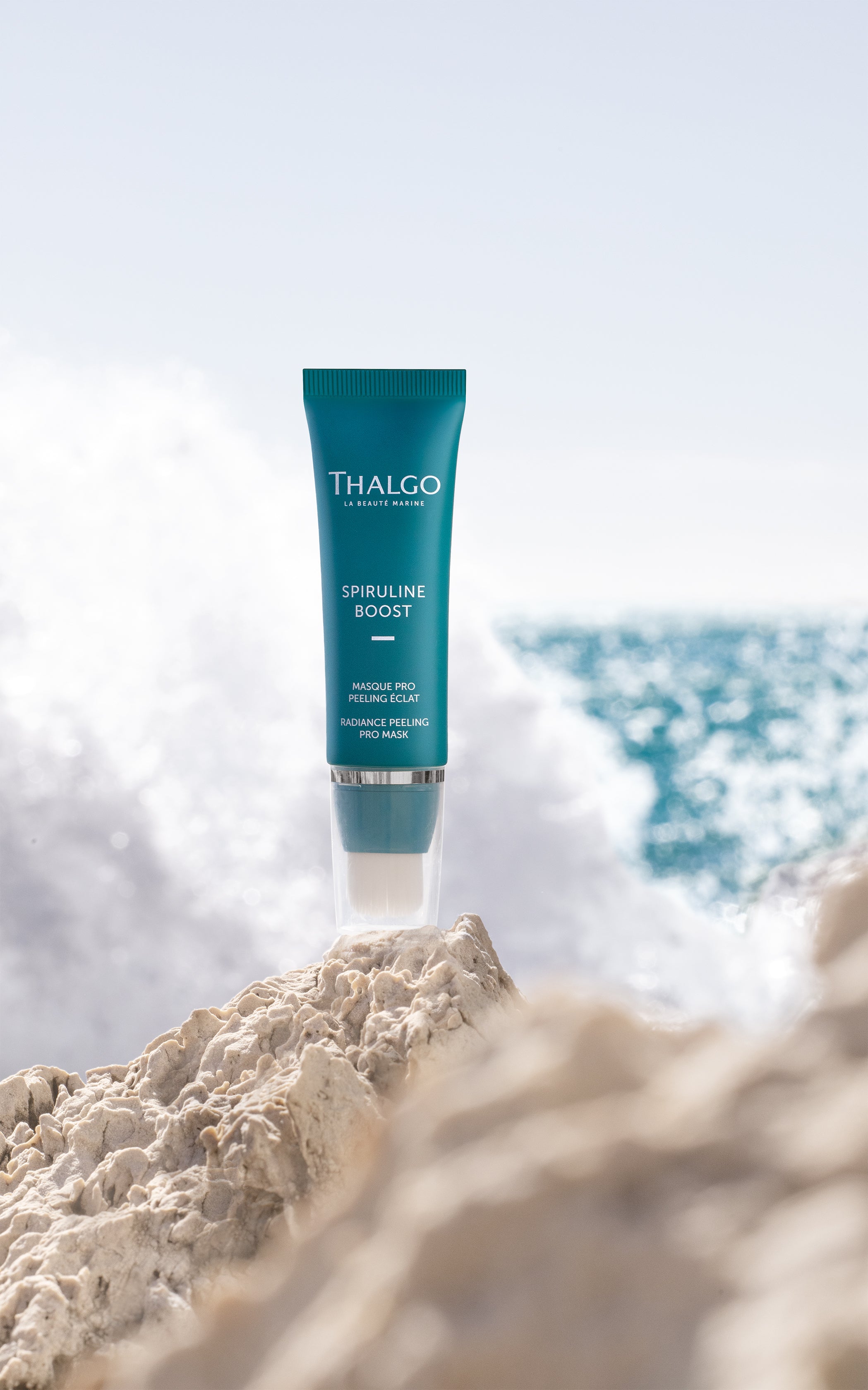 THALGO Spirulina Boost - Vitalisierende Peeling-Maske – 50ml, Tube auf Steinufer am Meer