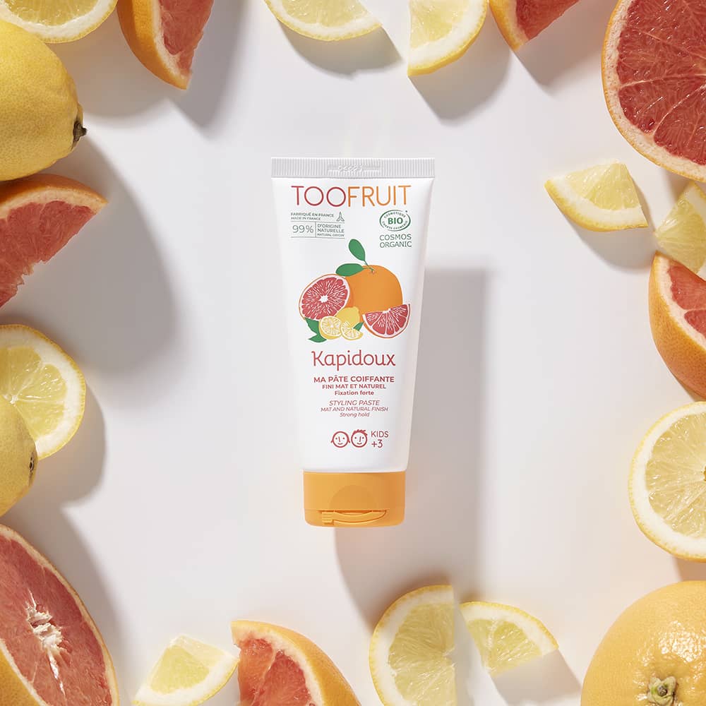 TOOFRUIT Kapidoux Styling-Gel – Zitrone - Grapefruit, 100g, Tube umringt von Blutorangen und Zitronen