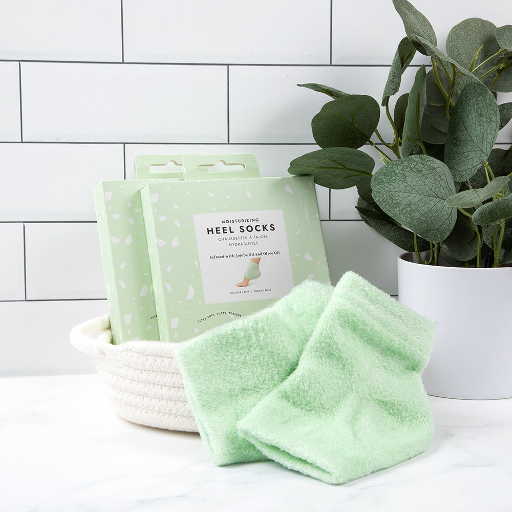 VOESH Moisturizing Heel Socks – mint, 1Paar, Umkarton und Fersensocken in Körbchen neben Zimmerpflanze