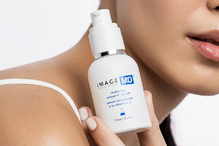 Frau hält ein Gesichtsserum von IMAGE Skincare in der Hand.