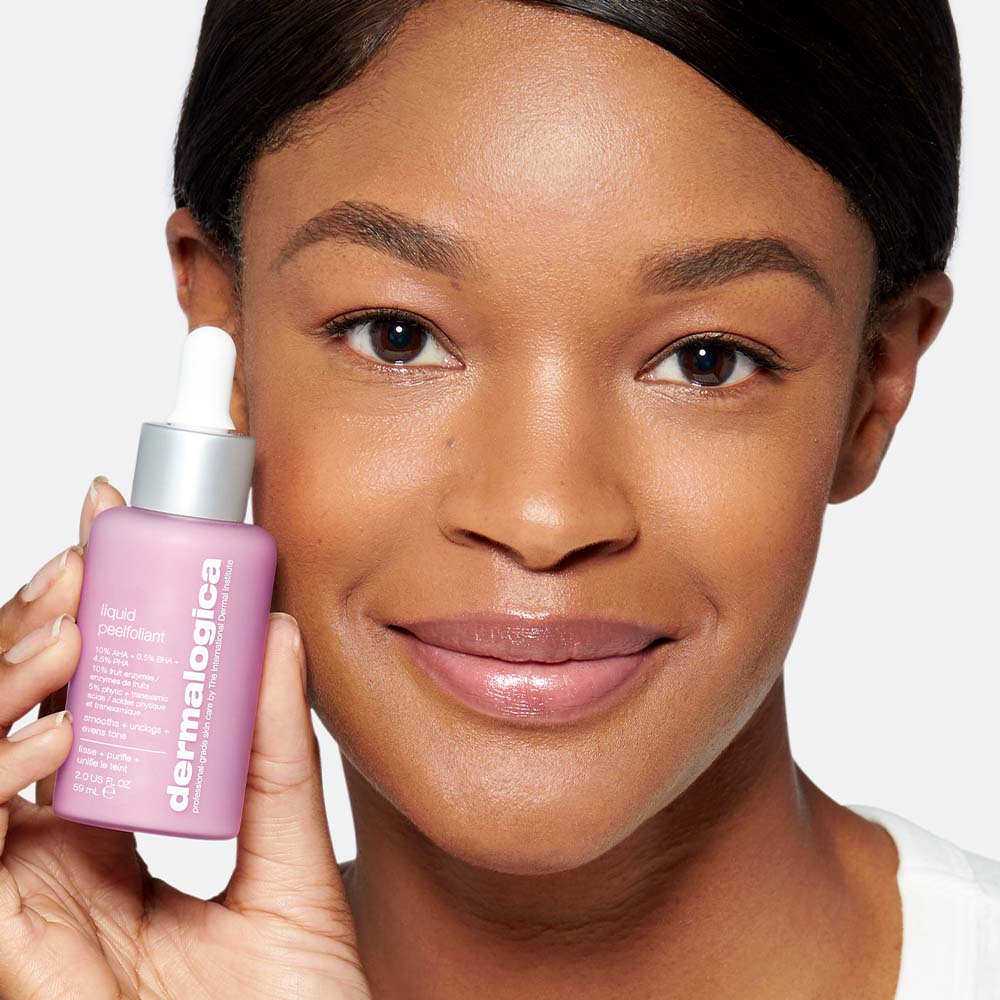 DERMALOGICA Liquid Peelfoliant – reduziert das Erscheinungsbild feiner Linien sowie Fältchen und verkleinert die Poren sichtbar nach nur einer Anwendung., 59ml, Frau zeigt Produkt