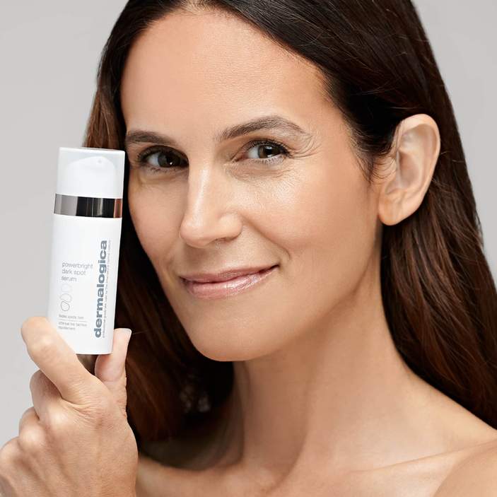 DERMALOGICA  Powerbright Dark Spot Serum – lässt innerhalb von 7 Tagen Pigementflecken verblassen und wirkt so schnell gegen Hyperpigmentierungen., 30ml, Frau zeigt Serum