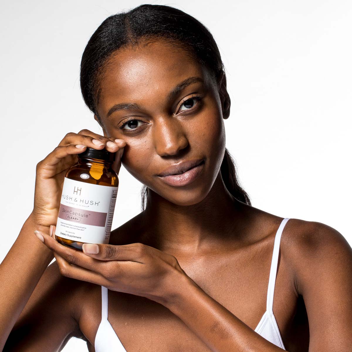 HUSH & HUSH Skincapsule™ Clear+ – Nutraceutical, 50g, Frau hält Dose