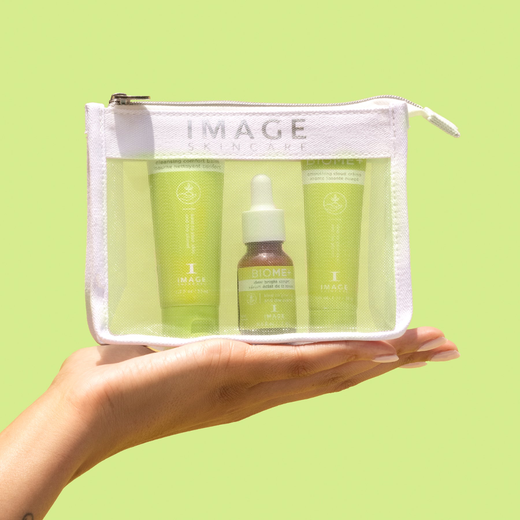IMAGE SKINCARE BIOME+ Microbiome Essentials travel set – 1stk, Hand hält Kosmetiktasche mit Produkten