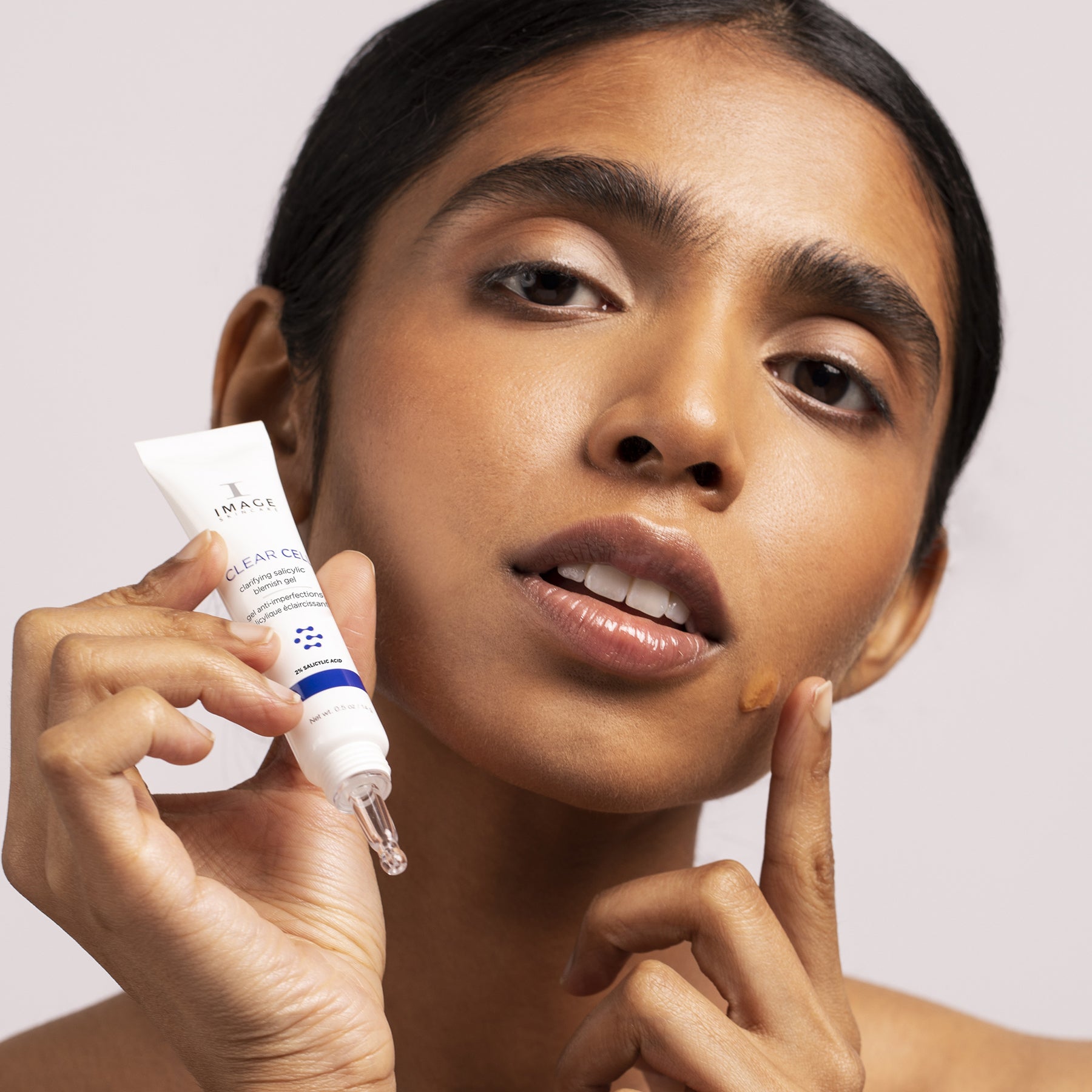 IMAGE SKINCARE CLEAR CELL clarifying salicylic blemish gel – Spot-Treatment, 14g, Frau hält Tube