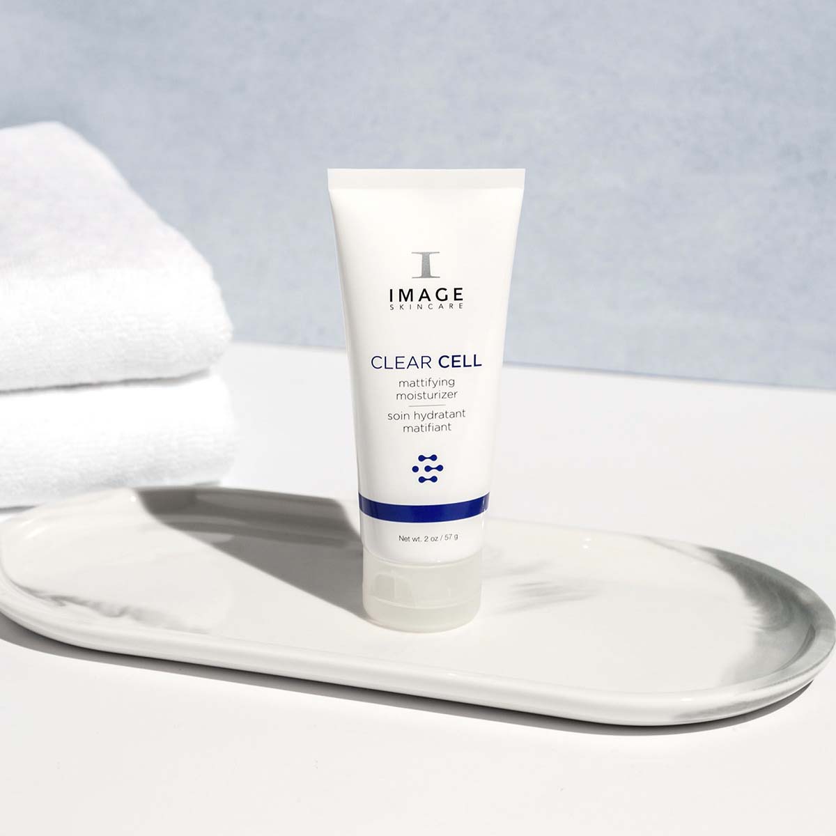 IMAGE SKINCARE CLEAR CELL Mattifying Moisturizer – Mattierender Moisturizer für unreine Haut, 57g, Tube stehend auf Tablett mit Handtüchern