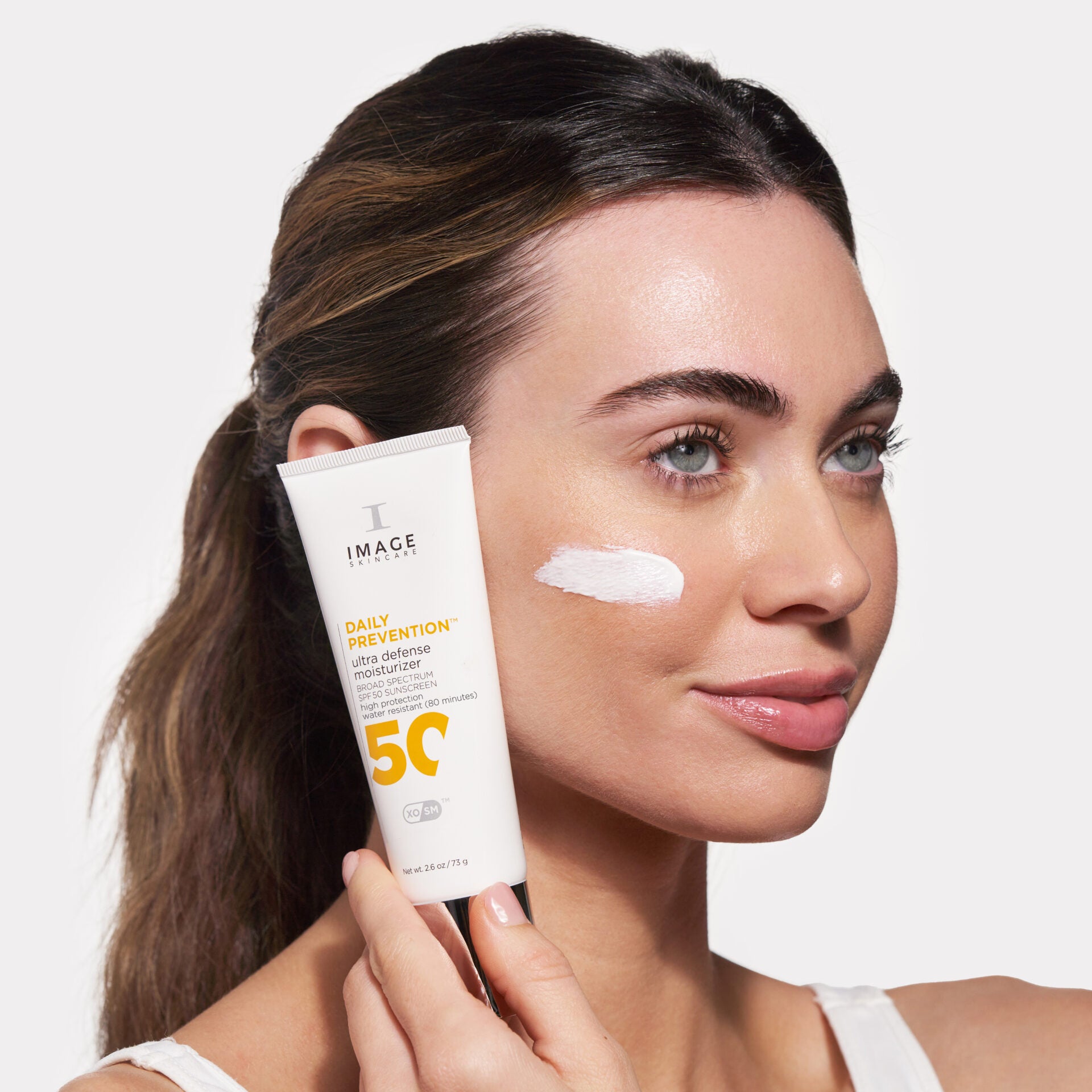 IMAGE SKINCARE DAILY PREVENTION ultra defense moisturizer SPF 50 – Sonnenschutz, 73g, Frau hält Tube