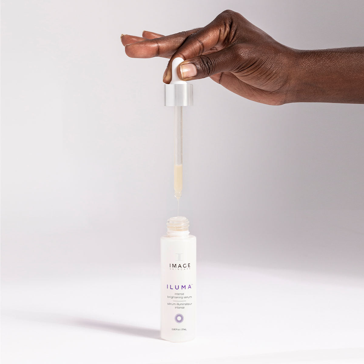IMAGE SKINCARE ILUMA™ Intense Brightening Serum  – aufhellende Pflege gegen Pigmentflecken, 30ml, Hand entnimmt Serum mit Pipette