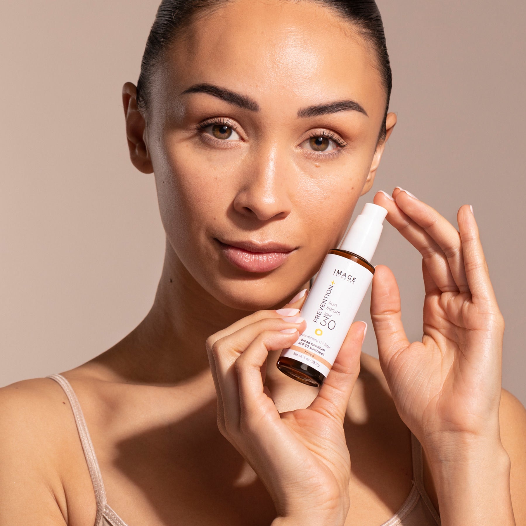 IMAGE SKINCARE Prevention+ sun serum tinted SPF 30 – Getöntes Sonnenschutzserum, 28,3g, Frau hält Serum
