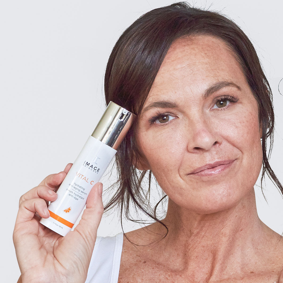 IMAGE SKINCARE Vital C Hydrating Anti-Aging Serum – 50ml, Frau hält Serum 