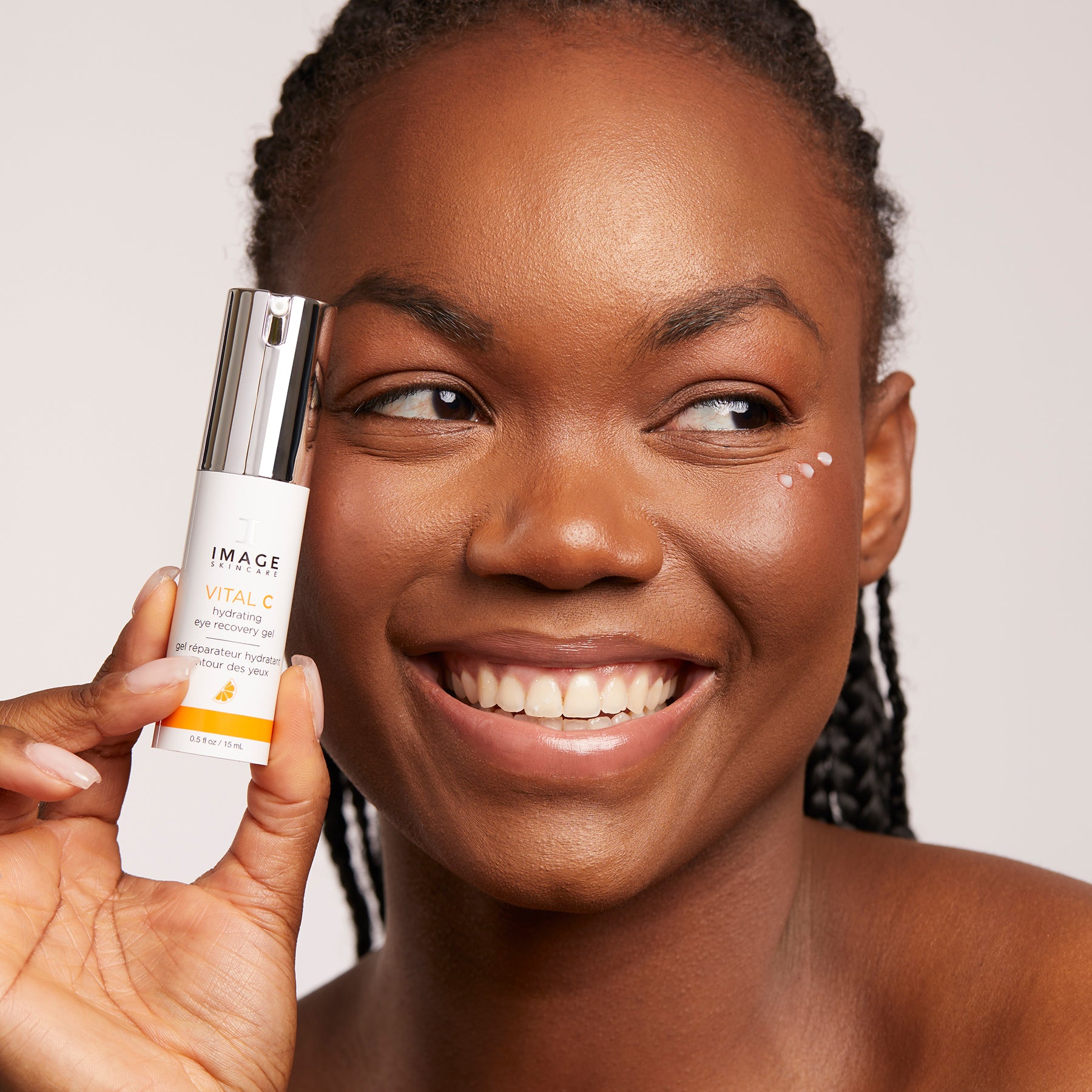 IMAGE SKINCARE Vital C Hydrating Eye Recovery Gel  – Augenpflege gegen Augenringe & Fältchen, 15ml, Frau hält Pumpspender an Gesicht