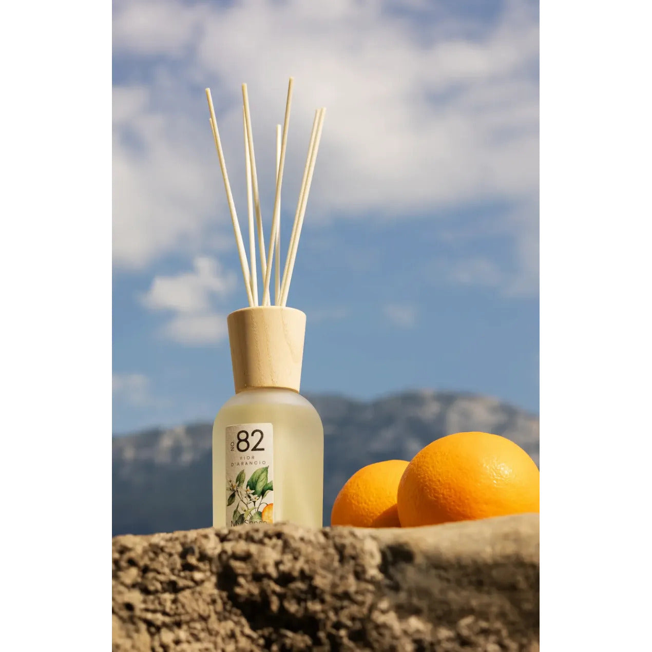 MYSENSO Raumduft N°82 Fior D'Arancio  – 240ml, Flacon Orangen auf Steinplatte vor blauem Hintergrund