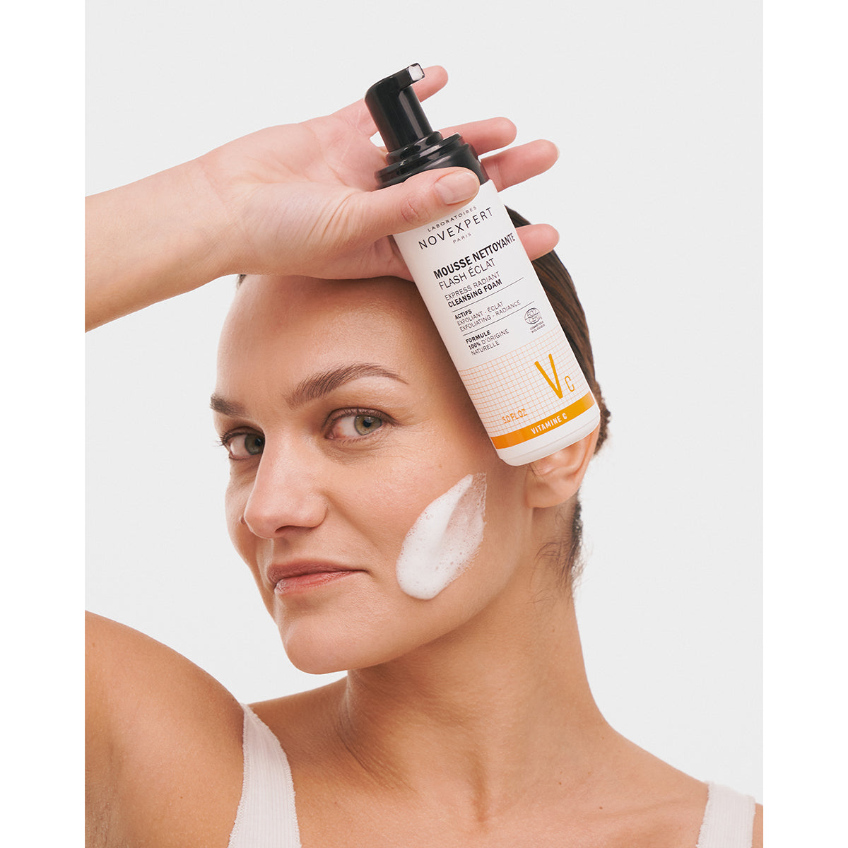 NOVEXPERT Express Radiance Cleansing Foam – 150ml, Frau hält Schaumspender