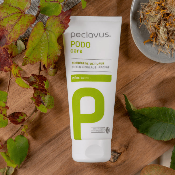 PECLAVUS Fußcreme Weinlaub  – 100ml, Tube auf Holz liegend mit Weinblättern