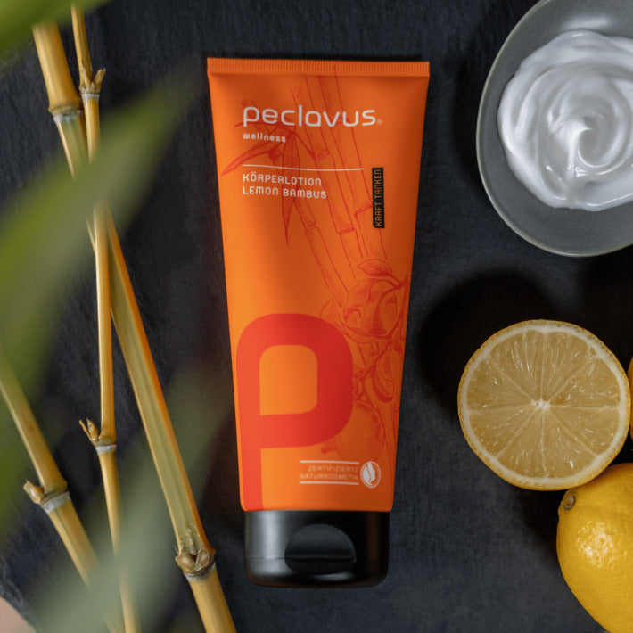 PECLAVUS Körperlotion Lemon Bambus  – 200ml, Tube auf Schieferplatte liegend mit Bambus und Zitronenscheiben