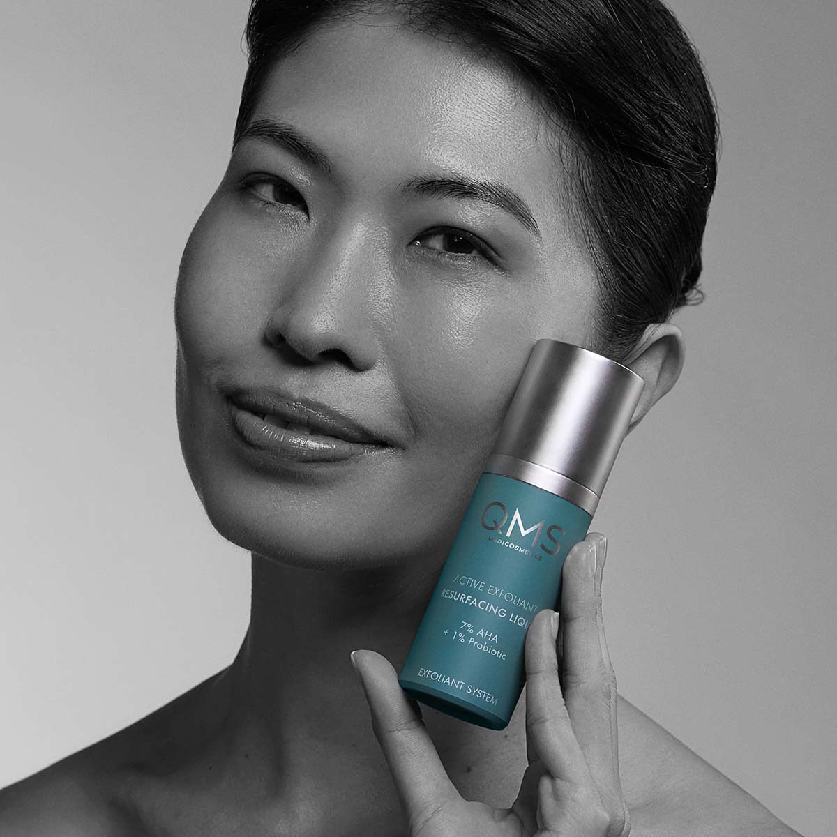QMS 7% AHA Active Exfoliant Resurfacing Liquid  – für sensible Hauttypen, 30ml, Frau hält Spender